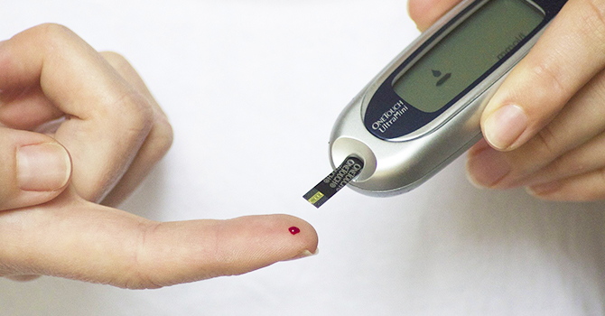 Person testing their glucose levels with a glucose meter.
