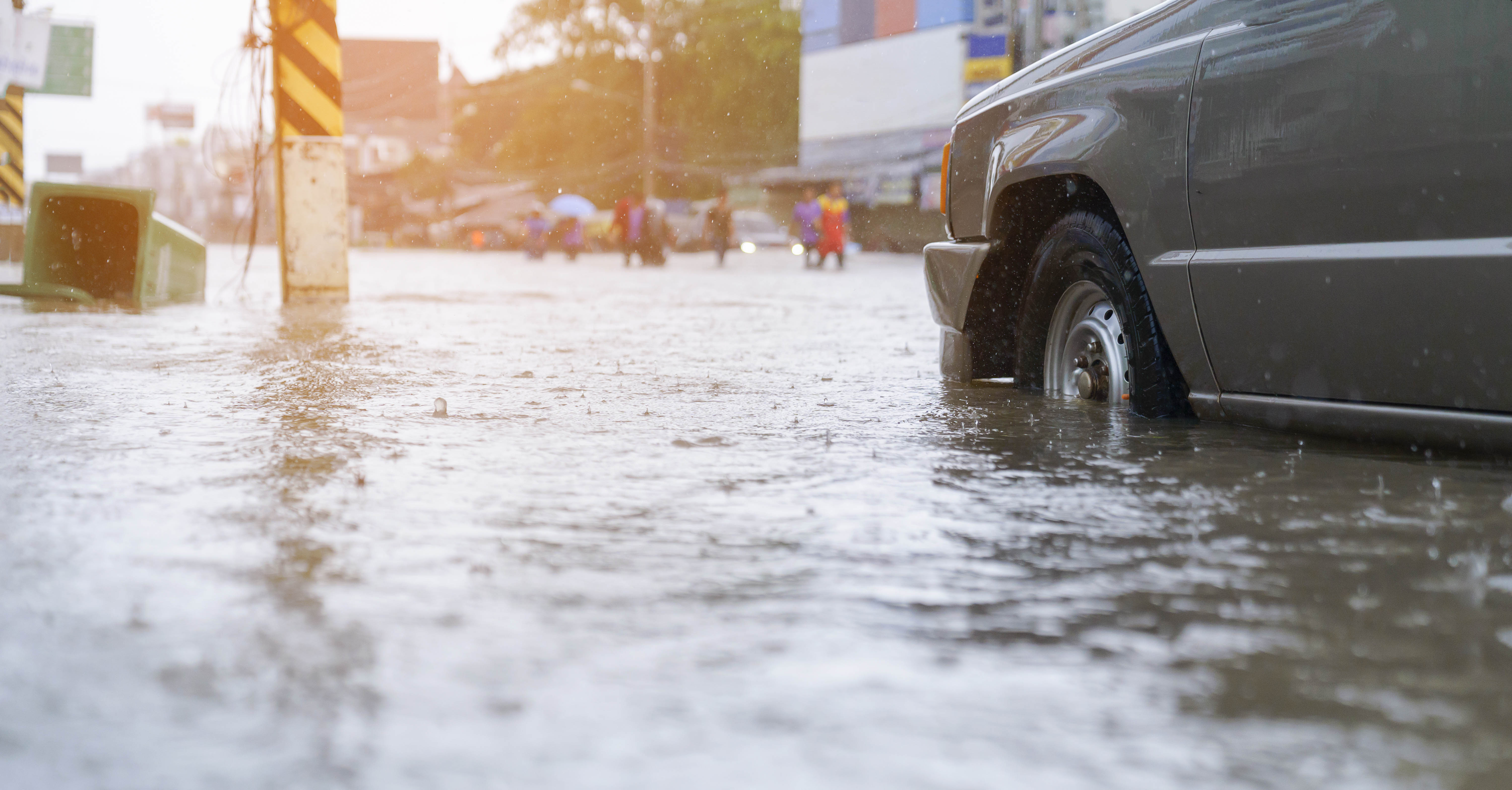 A car drives down a flooded street